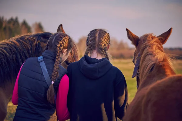 Twee Tienermeisjes Met Gevlochten Paardenstaarten Staan Met Hun Rug Naar — Stockfoto