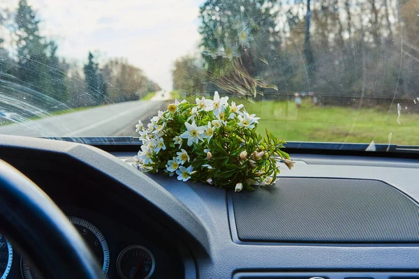 Flores de primavera en el torpedo de los coches bajo el parabrisas. — Foto de Stock