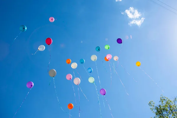 Palle di diversi colori su cielo blu — Foto Stock