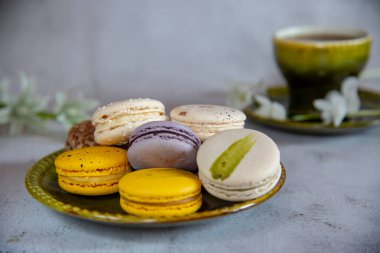 Bir kaç lezzetli rengarenk badem kurabiyesi bir tabağın üzerinde yatıyor..