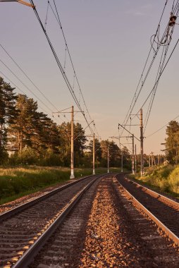 Bir yaz akşamı raylı ve demiryolu ile sanayi manzarası.