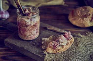 Ev yapımı güveç ve ahşap bir kesme tahtasının üzerinde iştah açıcı bir sandviç. Yemek geçmişi. Fotoğraf gösterişsiz..