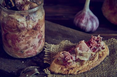 Ev yapımı güveç ve ahşap bir kesme tahtasının üzerinde iştah açıcı bir sandviç. Yemek geçmişi. Fotoğraf gösterişsiz..