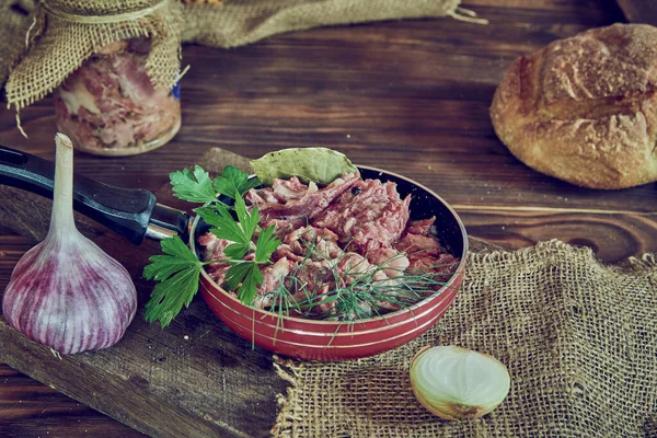 木製のカウンターに新鮮なハーブで味付け煮込み肉とフライパン 食品の背景 — ストック写真