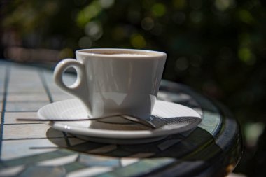 Yazlık bir kafede masanın üstünde bir fincan kapuçino..