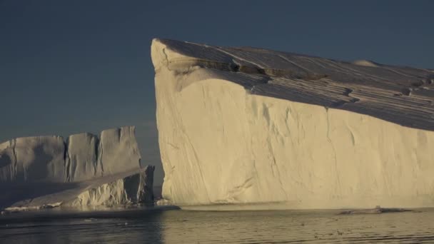 Grönland. Isberg vid solnedgången. Grönlands natur och landskap. Diskobukten. Sommaren midnattssol och isberg. Stor blå is i — Stockvideo