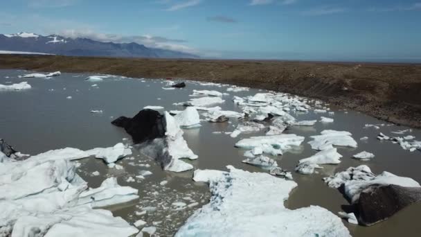 Vista aérea. Icebergs y trozos de hielo flotando en la laguna glaciar de Jokulsarlon. Islandia. — Vídeos de Stock