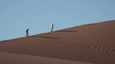 Namibya. Namib Çölü, Sossusvlei. İnsanlar Namibya, Afrika 'da dünyanın en yüksek kum tepeleri boyunca yürüyüş yaparlar. Ünlü olmak.