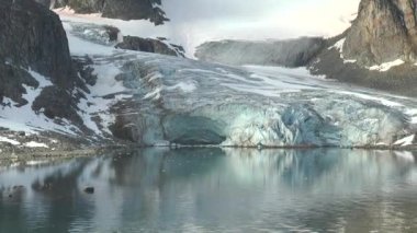 Gezinti. Kuzeye gemi yolculuğu yap. Gün doğumunda denizden görülen kuzey manzaralı karlı dağ. Norveç vahşi