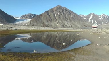 Gezinti. Kuzeye gemi yolculuğu yap. Gün doğumunda denizden görülen kuzey manzaralı karlı dağ. Norveç vahşi