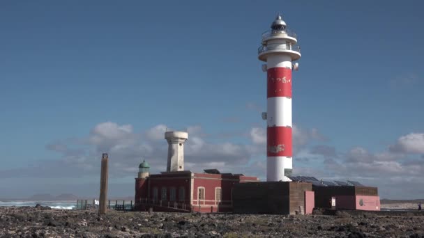 Fyrtårn. Det gamle røde fyrtårnet. Blå havbakgrunn. Navigasjonsutstyr på havet. – stockvideo