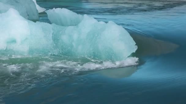 Global warming. Iceland. Melting glaciers and icebergs in the lagoon. A big melting ice block floating towards the ocean in — Stock Video