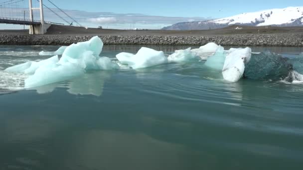 Globális felmelegedés. Izland. Olvadó gleccserek és jéghegyek a lagúnában. Egy nagy olvadó jégtömb lebeg az óceán felé — Stock videók