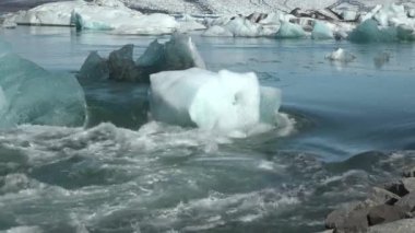 İzlanda. Buzul gölü. Yüzen buzdağları. Jokulsarlon, İzlanda 'nın güneydoğusunda Vatnajokull Ulusal Parkı yakınlarında bulunan bir buzul gölüdür. 4K UHD video.