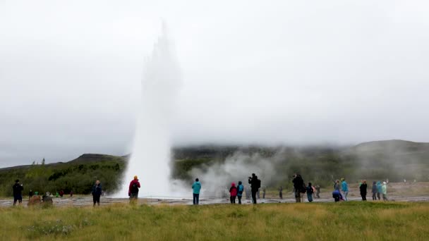Izland. Turisták nézni a kitörés a gejzír Strkkur. — Stock videók