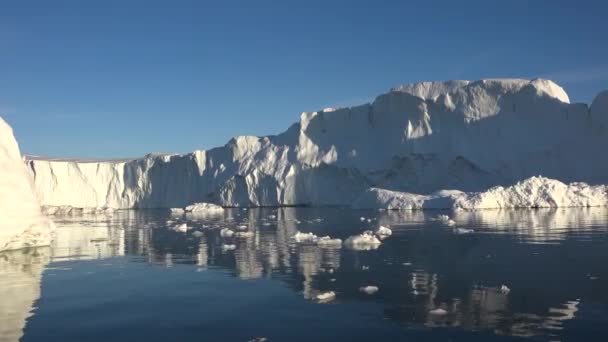 Antarktická příroda. Obrovský dlouhý ledovec se zrcadlovým odrazem se vznáší v otevřeném oceánu. Dramatický západ slunce obloha v pozadí. — Stock video