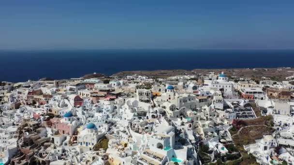 Rumah-rumah putih terkenal dan kubah biru di tepi tebing. Oia, Santorini. Yunani. Tampilan udara. — Stok Video