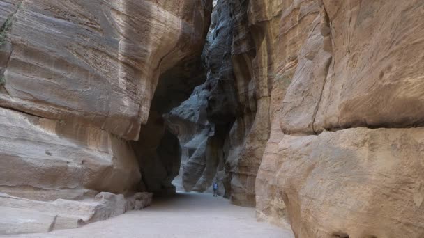 Turista prochází kamenným kaňonem starobylého města Petra v Jordánsku. — Stock video