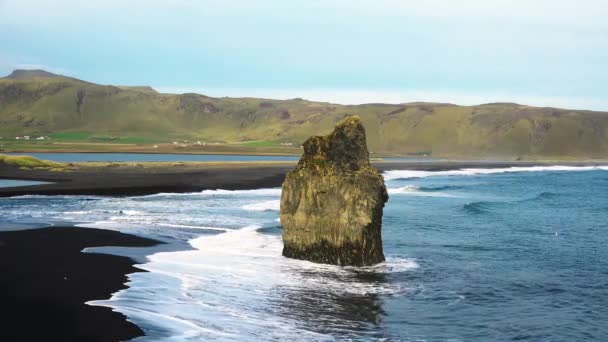IJsland. Kleurrijke warme zonsondergang boven de zee en vulkanische basalt rotsen. De golven storten neer in de rots, verlicht door de — Stockvideo