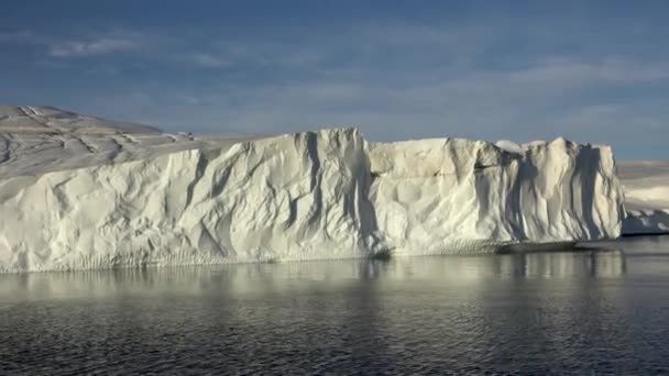 Berlayar di sepanjang tebing es gletser mencapai laut. Gunung es. — Stok Video