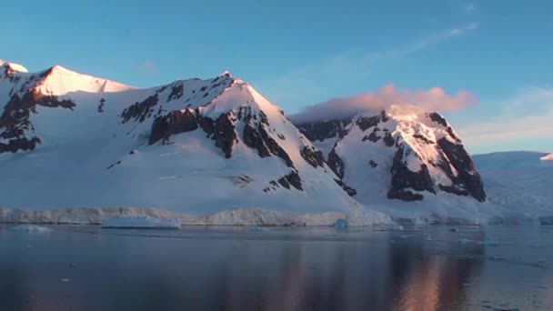 Tramonto in Antartide, con acqua di mare calma che riflette bella e pittoresca arancione, giallo e blu e montagne con coste rocciose — Video Stock