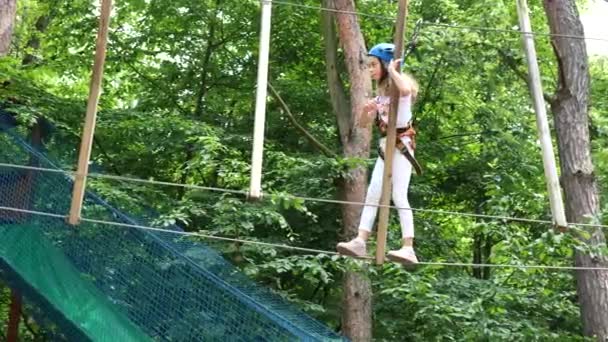 여름에 안전 장비를 갖춘 모험 공원의 행복 한 소녀. 로페 파크는 자연을 타고 다닌다. 행복 — 비디오