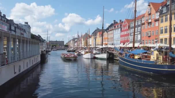 Dinamarca. Copenhagem.03.08.2019. (em inglês) Canal Nyhavn, importante marco de Copenhague. Casas coloridas fachadas e barcos à vela. Reflexão da água, ensolarado — Vídeo de Stock