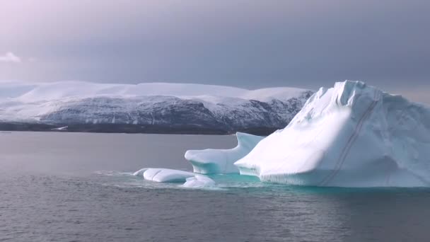 グリーンランドのイルリサット。ディスコ湾の晴れた日に氷河の岸近くに浮かぶ巨大な氷山. — ストック動画