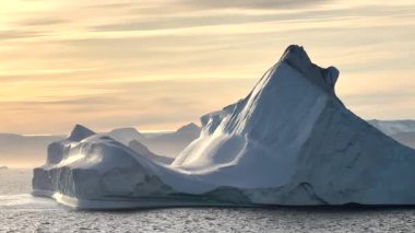 Baffin Adası 'nın nefes kesen sahil güzelliğini tecrübe edin. Parlayan buzdağlarının dingin sularla buluştuğu yer şafak vakti dağların arkası..