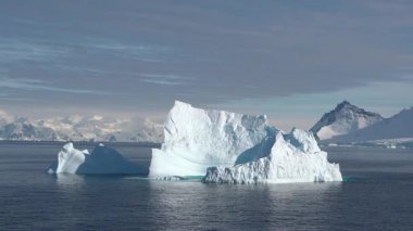 Baffin Adası 'nın nefes kesen sahil güzelliğini tecrübe edin. Parlayan buzdağlarının dingin sularla buluştuğu yer şafak vakti dağların arkası..