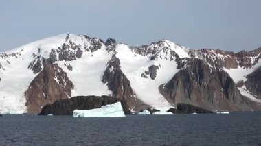 Sakin Kuzey Kutbu günbatımında dramatik kayalıkların yanında okyanusta yüzen buzdağlarının nefes kesici güzelliğine tanık olun. Doğa bu el değmemiş çevrede mucizeler yaratır..