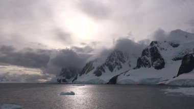 Sakin Kuzey Kutbu günbatımında dramatik kayalıkların yanında okyanusta yüzen buzdağlarının nefes kesici güzelliğine tanık olun. Doğa bu el değmemiş çevrede mucizeler yaratır..