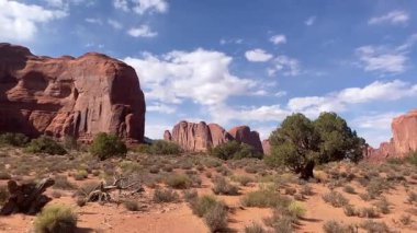 Etrafı dağınık bitki örtüsüyle çevrili görkemli kumtaşı oluşumları çöl zemininden yükseliyor. Güneş ışığı, Anıt Vadisi 'ndeki ikonik manzaranın canlı renklerini aydınlatır..