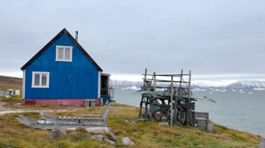 Parlak renkli evler okyanusa yakın, buzdağlarıyla çevrili. Bulutlu gökyüzü bu sakin Grönland manzarasına eşsiz bir ortam ekler. Doğa ve kültür burada güzel bir şekilde harmanlanır..