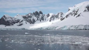 Antarktika 'daki kutup buzu, sakin sulara ve sürüklenen buzdağlarına yansıyan parlak güneş ışığında görüldüğü gibi, iklim değişikliği nedeniyle yavaş yavaş eriyor..