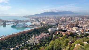 İnsanlar Malaga, İspanya 'da bir yolda yürüyor. Uzakta her iki tarafta ağaçlar ve binalar var. Hava güneşli ve açık. Bölgeyi parlak ve ziyaretçi dolu gösteriyor..