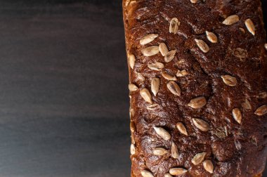 Koyu bir yüzeyde kepek tohumlu lezzetli taze ekmek, kopyalanmış yatay görüntü.
