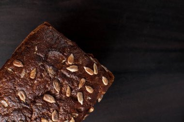 Koyu bir yüzeyde kepek tohumlu lezzetli taze ekmek, kopyalanmış yatay görüntü.