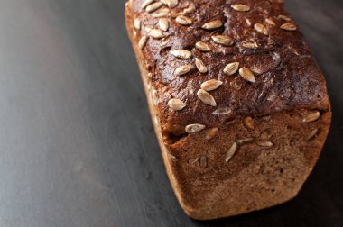 Lezzetli taze pişmiş kahverengi ekmek ve kepekli ayçiçeği tohumları.