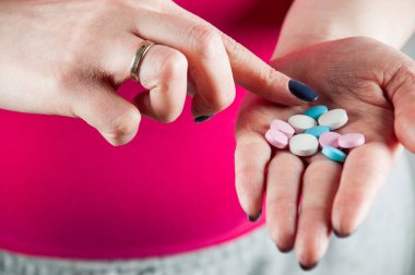 Hapları ve vitaminleri avuç içiyle karıştıran genç bir kız, Hori.