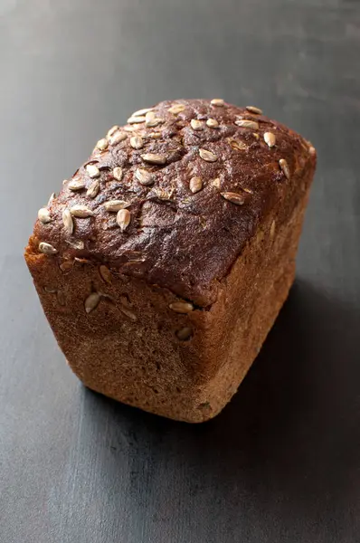 Lezzetli taze pişmiş kahverengi ekmek ve kepekli ayçiçeği tohumları.