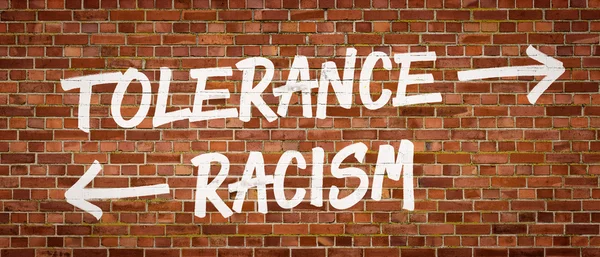 Tolerantie of racisme geschreven op een bakstenen muur — Stockfoto