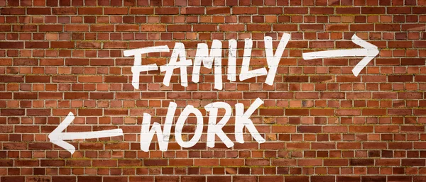 Famille ou travail écrit sur un mur de briques — Photo