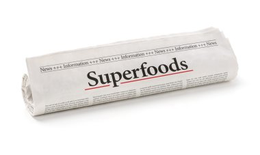 Rolled newspaper with the headline Superfoods clipart