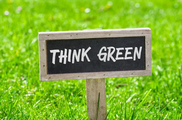 Sign on a green lawn - Think green — Stock Photo, Image