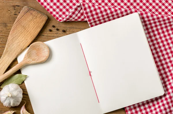 Boek met houten lepels op een rode geruite tafellaken — Stok fotoğraf