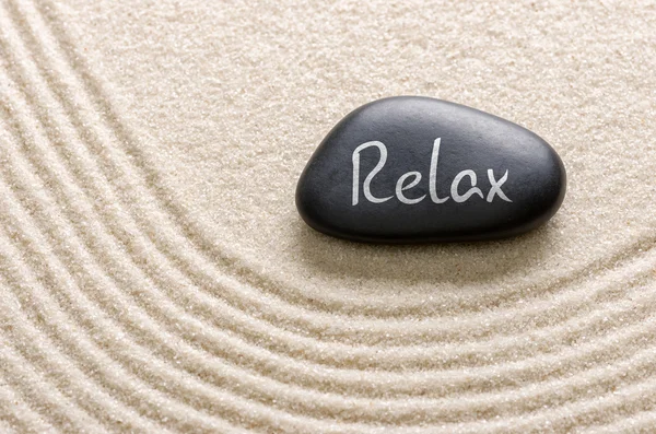 Piedra negra con la inscripción Relax — Foto de Stock