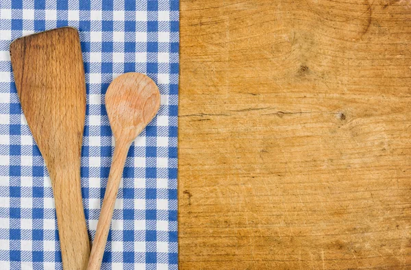 Wooden background with a blue checkered tablecloth and wooden spoon — Stock Photo, Image