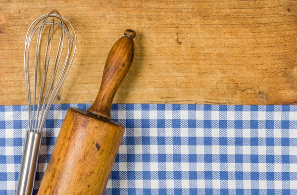 Whisk and wooden spoon on a wooden background — Stock Photo, Image