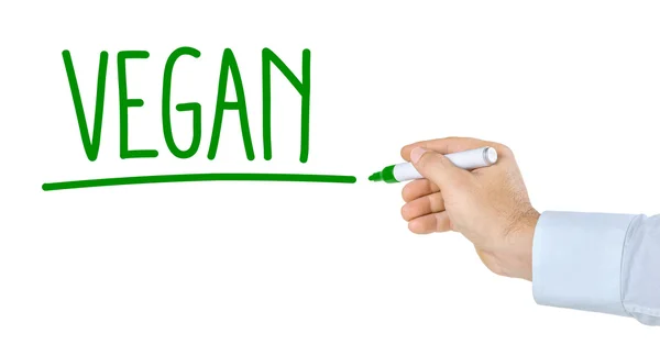 Hand mit Stift schreibt das Wort vegan — Stockfoto